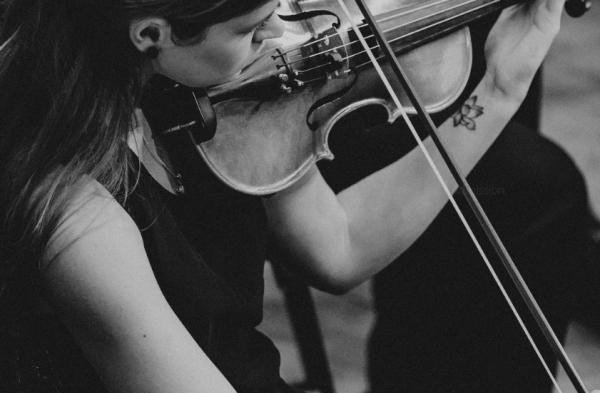 Imagem em preto e branco de uma mulher de vestido tocando um violino